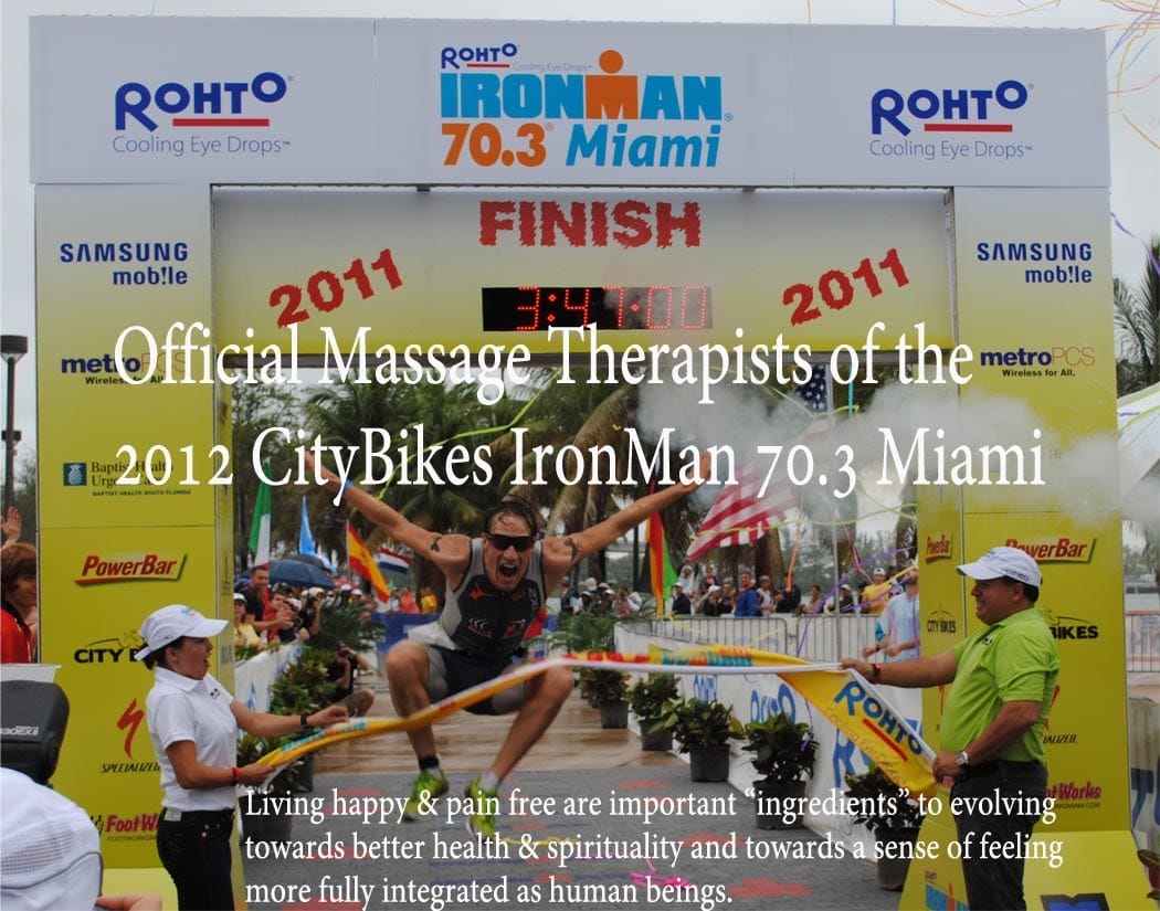 Finish line of the 2011 Rohto IronMan 703 Miami race with a triumphant athlete jumping in the air and officials around Banner promotes the official massage therapists for the 2012 CityBikes IronMan 703 Miami